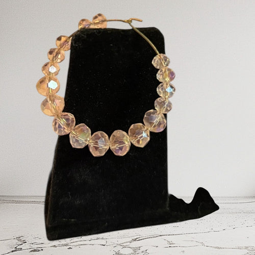 Handmade Trinkets champagne gold-tone hoop earrings with faceted crystal beads and iridescent aurora finish.