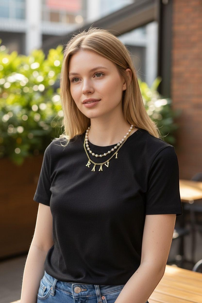Handmade Trinkets personalised gold letter name necklace with pearl chain worn by a woman.