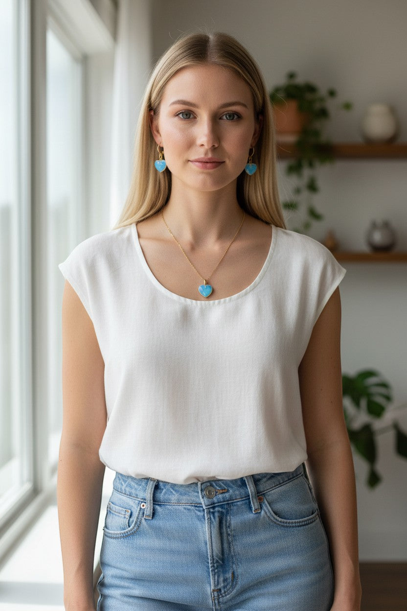 Handmade Trinkets blue opalite heart drop earrings with gold-tone hooks worn by a woman.